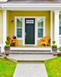Front entry door of bright yellow home
