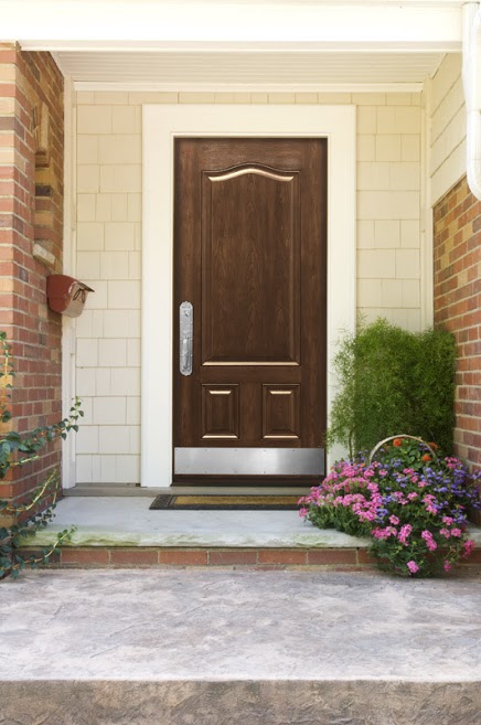 Brown front door of beige brick home 