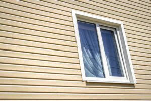 Close-up image of vinyl house siding and a window.