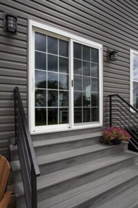 Sliding patio door installed on a home with gray siding.