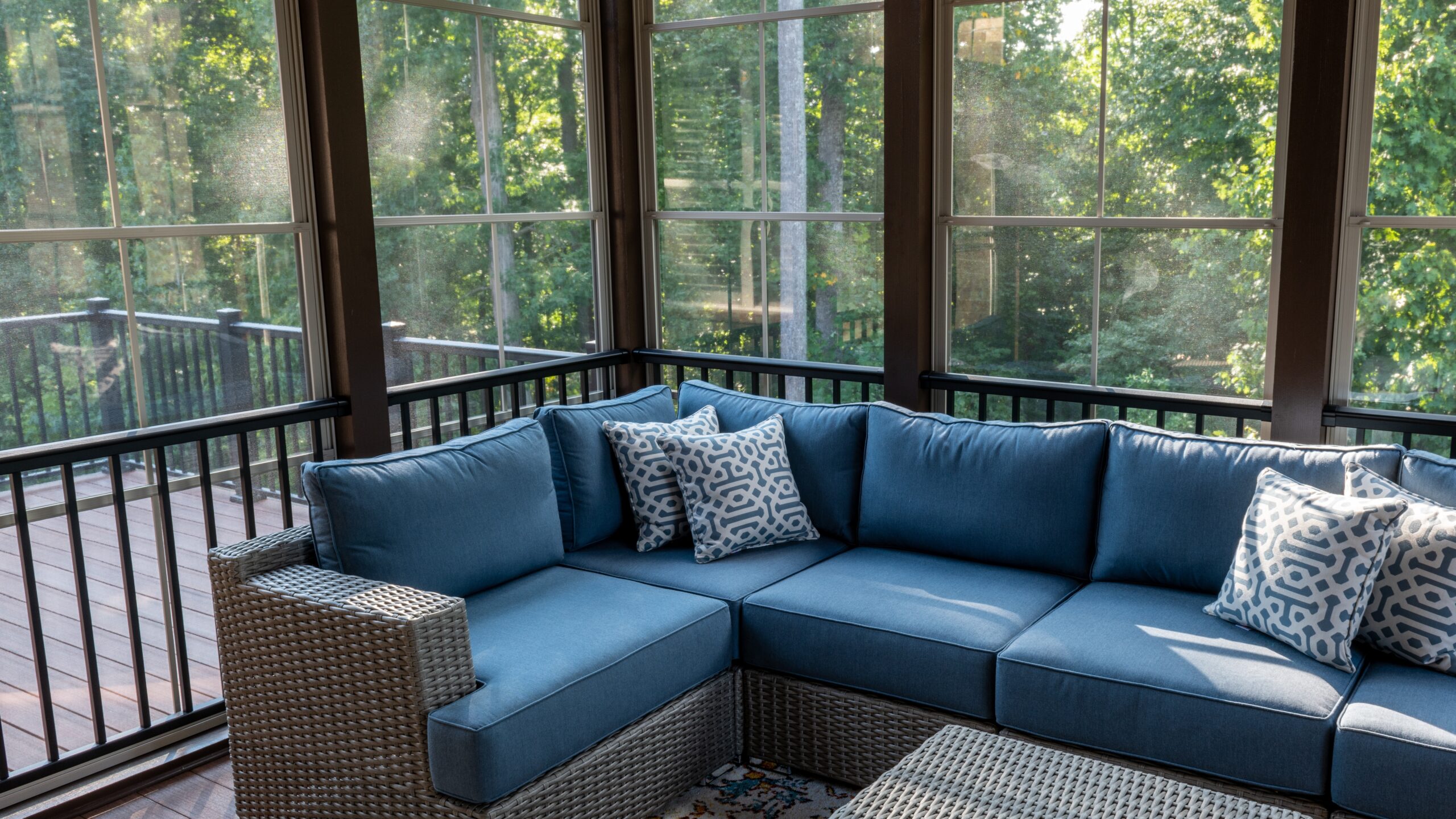 A sunroom with wood trim and a blue couch