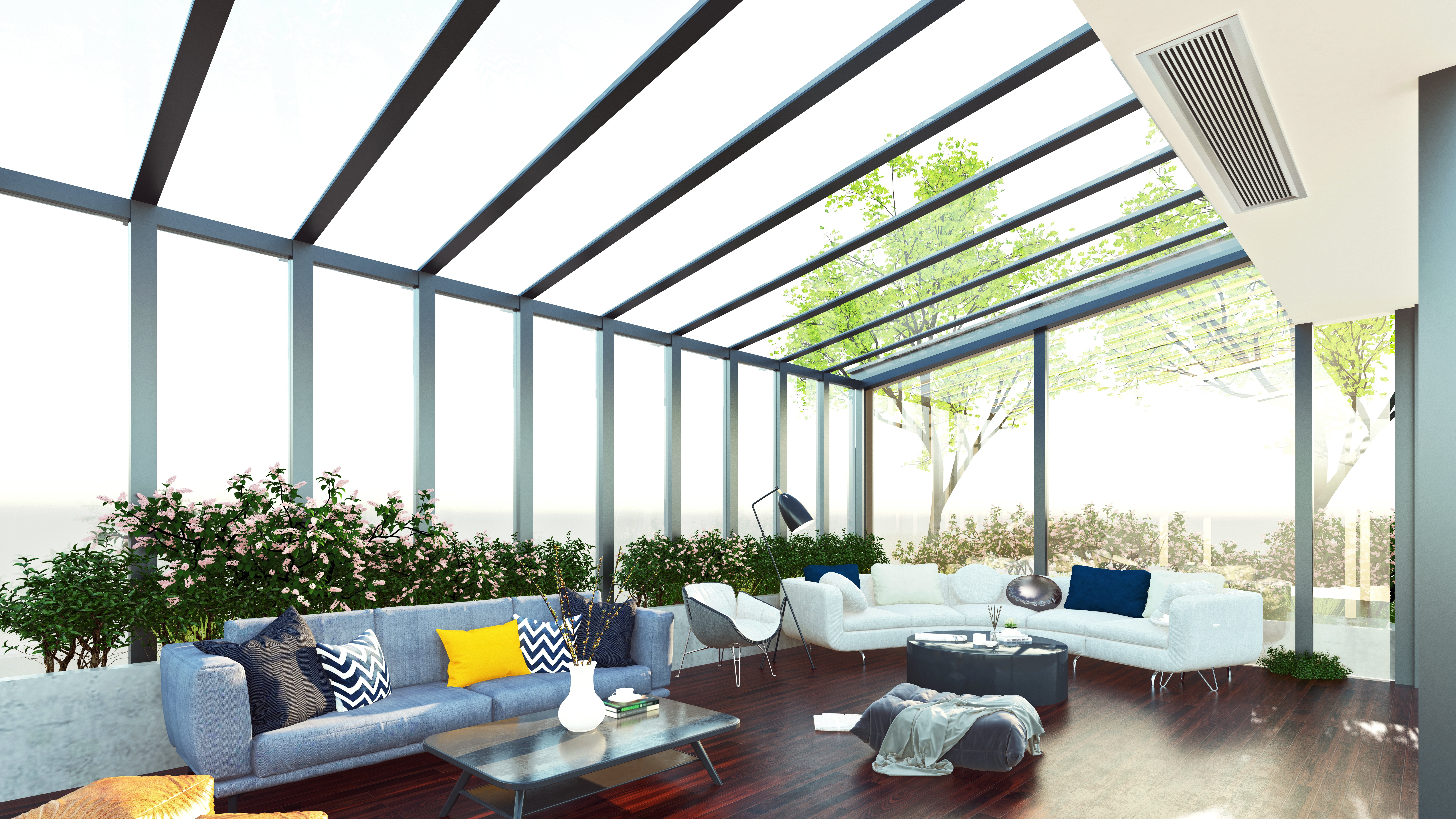 A sunroom with glass walls and ceiling with several couches