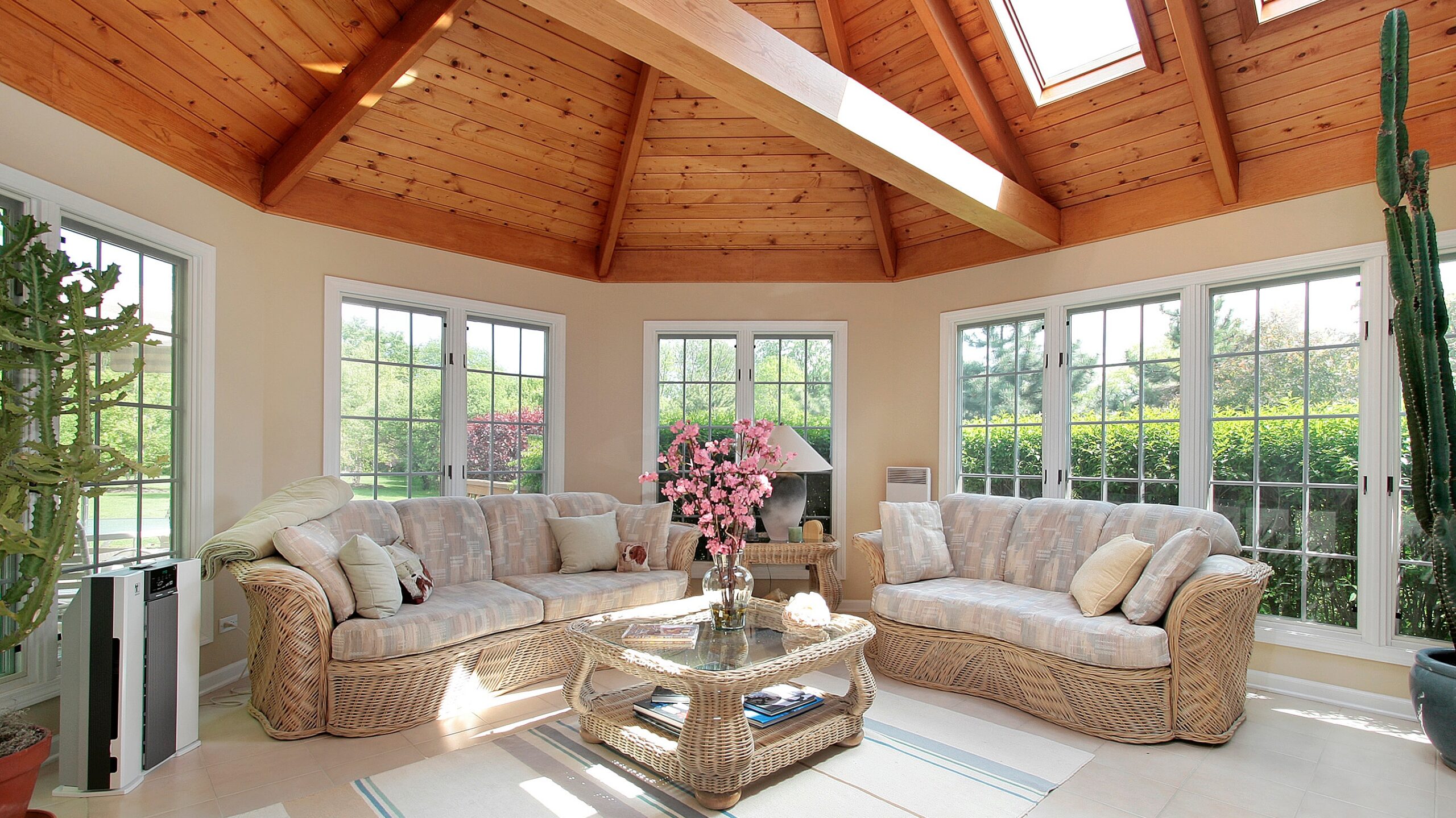 A sunroom with a wood beam ceiling and skylights