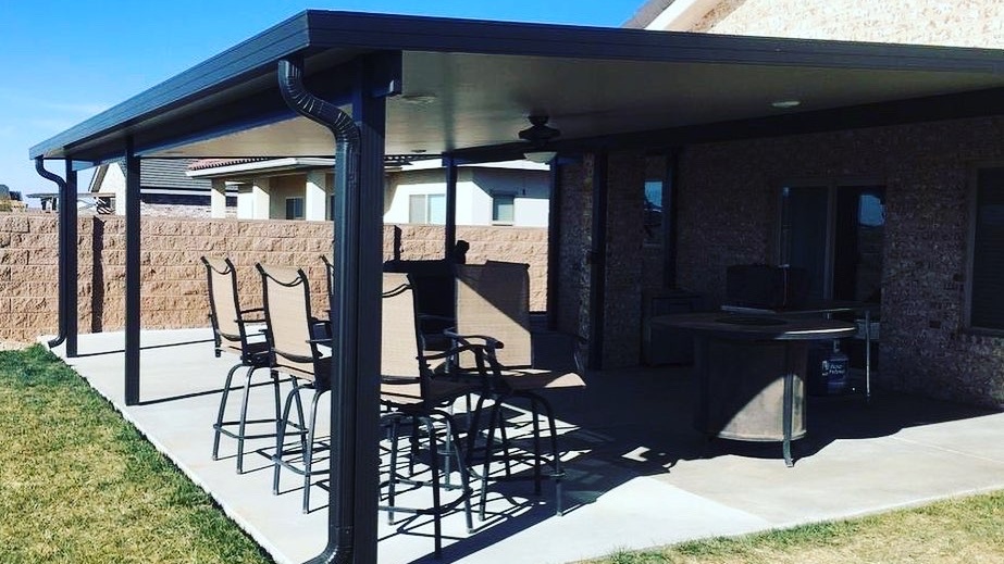 A patio cover over a full seating area attached to a brick home