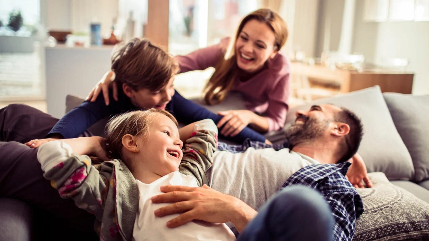 Family relaxing together in a bright, open living room, enjoying a comfortable space designed for spending time together.